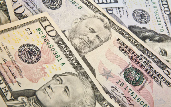 Разбросанные доллары в качестве фона — стоковое фото