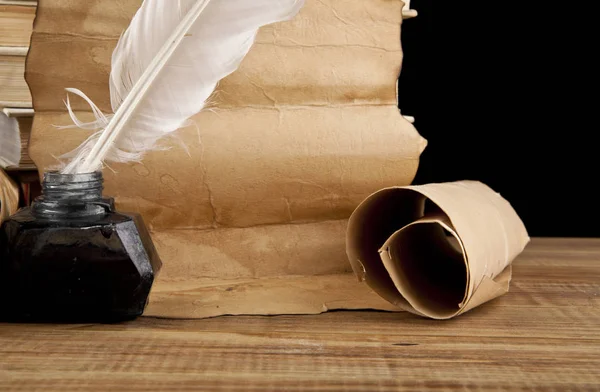 Papel viejo y tintero con una pluma sobre fondo negro —  Fotos de Stock