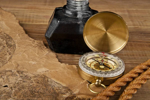 Oud papier, touw en kompas op een houten tafel — Stockfoto