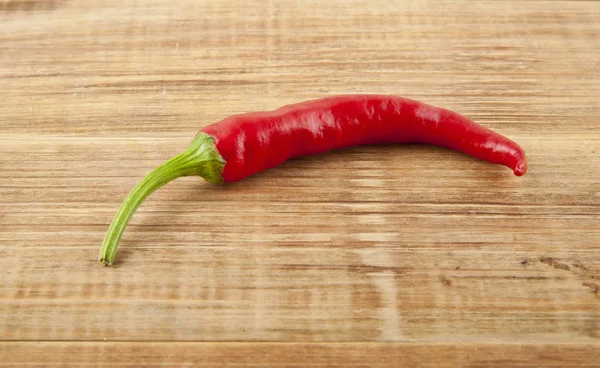 Červená paprika na dřevěném pozadí — Stock fotografie