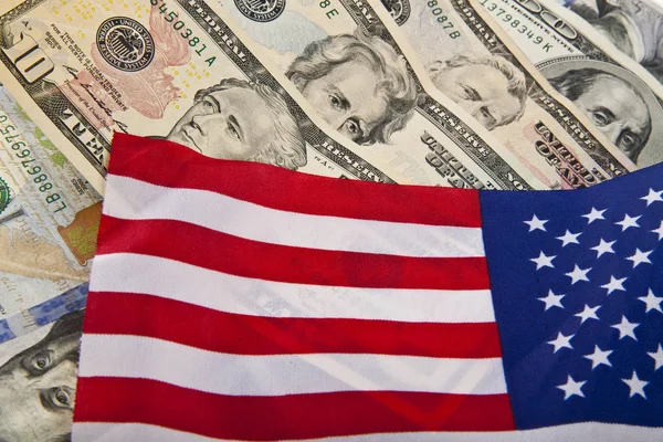 Доллары и флаг США в качестве фона — стоковое фото