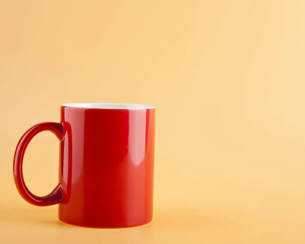 Red cup on a beige background — Stock Photo, Image