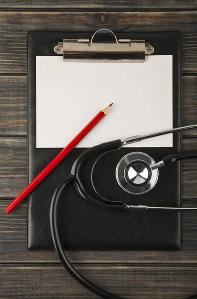 Tablet dla papieru, czerwony ołówek i stetoskop na drewniane backgro — Zdjęcie stockowe
