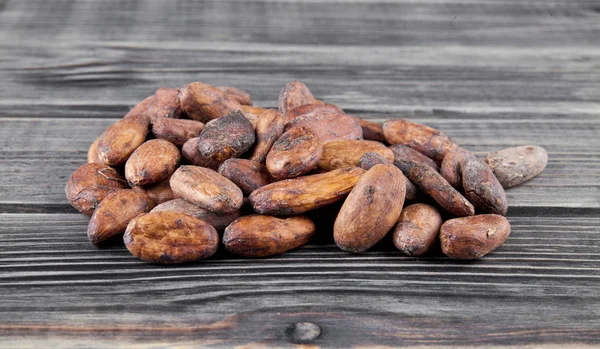 Granos de cacao sobre un fondo de madera —  Fotos de Stock