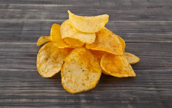 Potatis chips på en trä bakgrund — Stockfoto