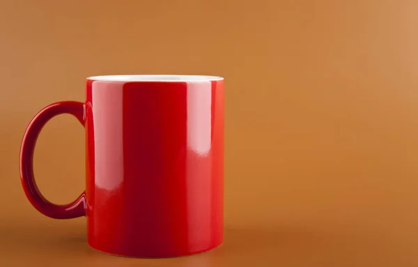 Κόκκινη κούπα σε καφέ φόντο — Φωτογραφία Αρχείου