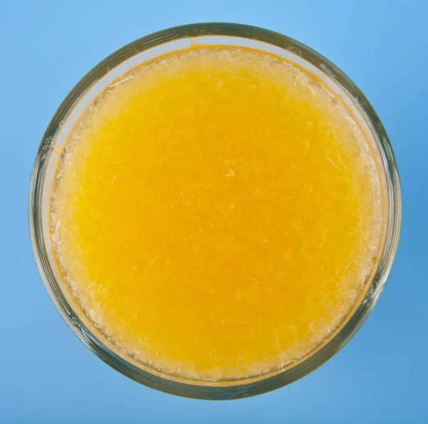 Orangensaft auf blauem Hintergrund — Stockfoto