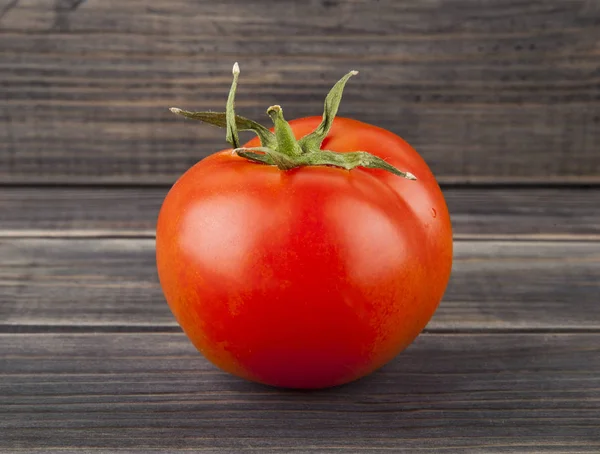 Tomates rojos, jugosos y frescos sobre un fondo de madera —  Fotos de Stock