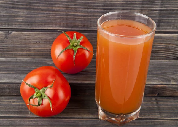 Czerwone, soczyste, świeże pomidory i sok na podłoże drewniane — Zdjęcie stockowe