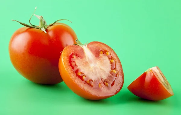 Tomates rojos sobre un fondo verde — Foto de Stock