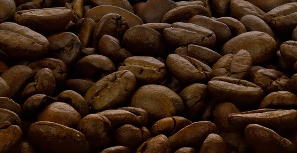 Granos de café tostados como textura para el fondo . —  Fotos de Stock