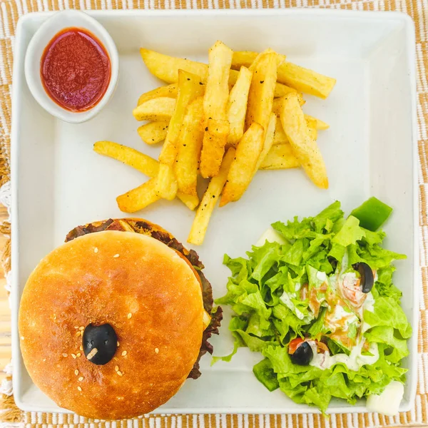 Burger mit Salat und Pommes lizenzfreie Stockfotos