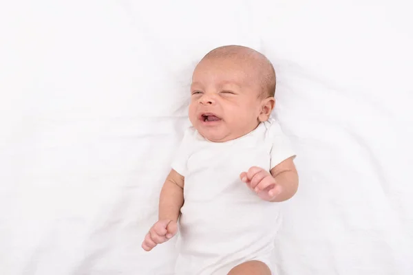 Новорожденный ребенок на белом листе — стоковое фото