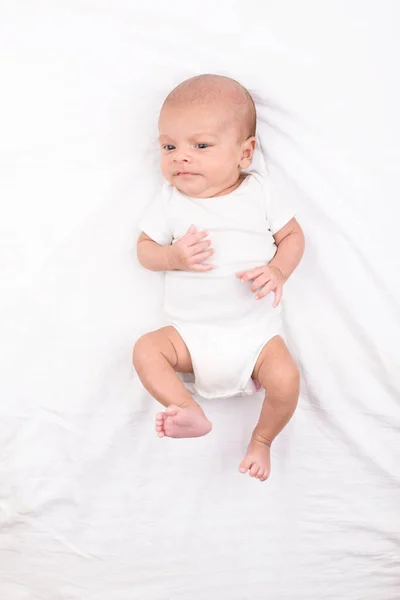 Newborn baby on white sheet — Stock Photo, Image