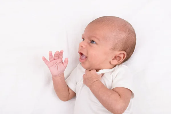 Новорожденный ребенок на белом листе — стоковое фото