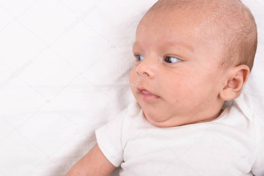 Newborn baby on white sheet