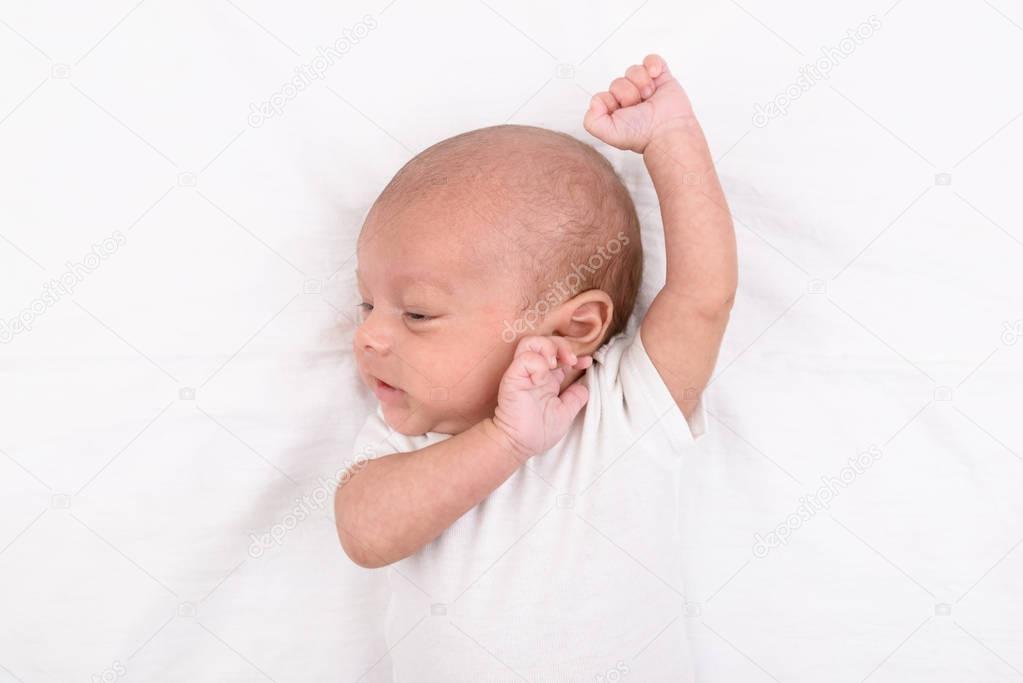 Newborn baby on white sheet