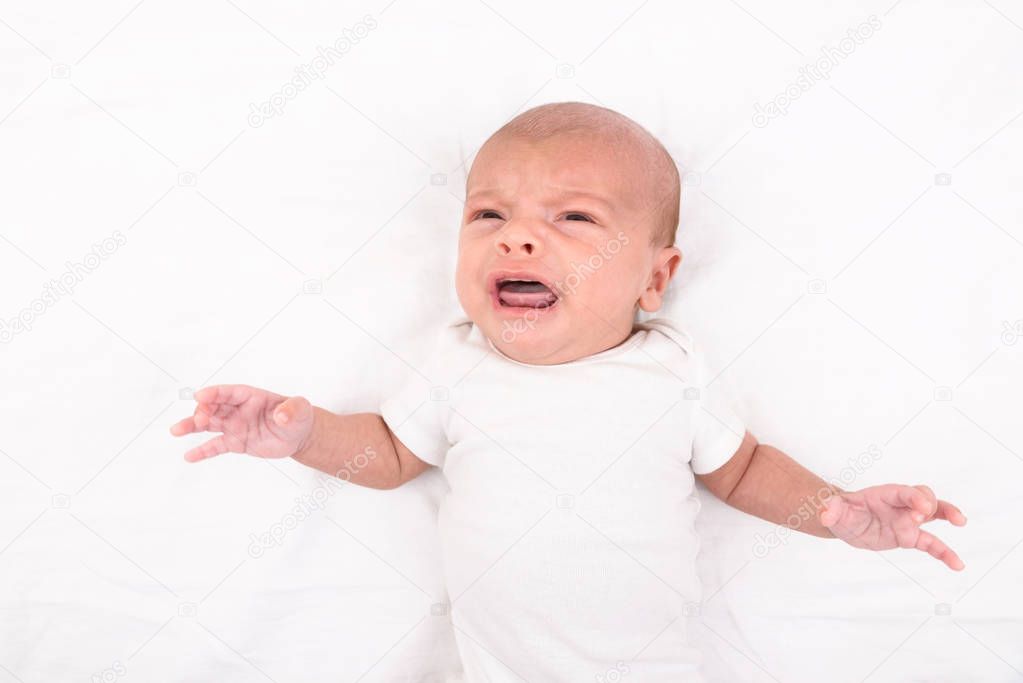 Newborn baby on white sheet