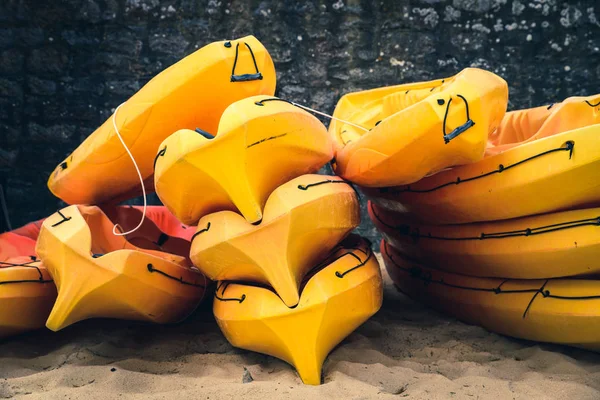 Caiaques empilhados em uma praia — Fotografia de Stock