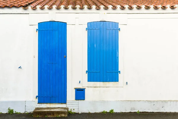 Fachada da casa com cortinas azuis e porta — Fotografia de Stock