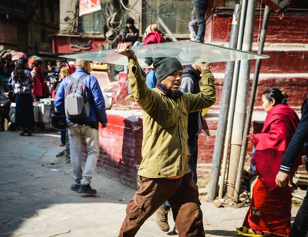 Man carrying a sheet of glass on his head, in Kathmandu, Nepal. — Stock Photo, Image