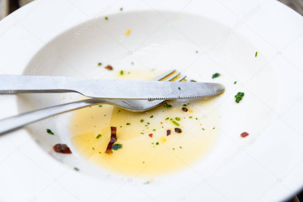 Empty plate with olive oil, herbs and chili leftover