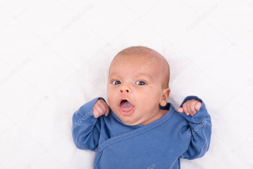 Newborn baby on white sheet