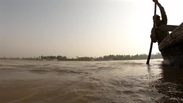 Zeitlupe eines nepalesischen Mannes, der im Kanu über einen Fluss paddelt — Stockvideo