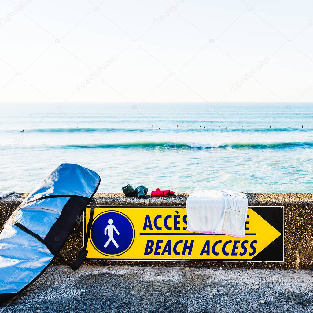 Beach access sign and surfboard