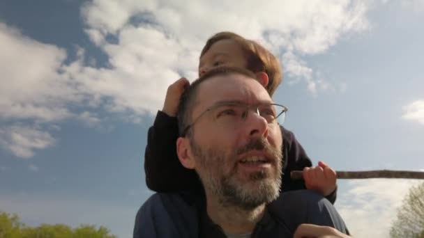 Ojciec noszący syna na ramionach — Wideo stockowe