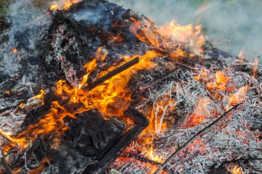Çiftçi, şenlik ateşi, açık havada şenlik ateşi ve tarım kavramında yeşil atıkları yakıyor. Düşen yapraklar, dallar ve ev çöpleri sonbahar yangınında yanar.
