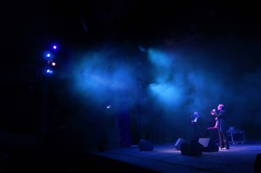 Sahne ışıkları. Gösterinin arka planı. Aydınlık spot ışıkları karanlıkta. Tiyatro sahnesinin içi projektöre aydınlatılmıştır. Konser sırasında sahne ışıkları ve sahne dumanı