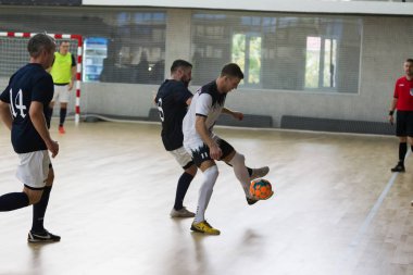 Odessa, Ukrayna - 11 Ekim 2019: Tanımlanamayan yerel takım oyuncuları parke zeminde kapalı alanda futbol oynuyorlar. Kapalı salonda, kapalı alanda oynanan futbol maçının doğru anı.