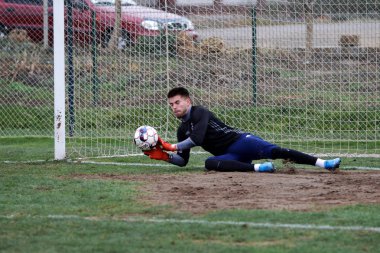 Odessa, Ukrayna - 2019 yılı: Yerel bir futbol takımının kalecisi, kötü bir futbol sahasında bölgesel bir derbi şampiyonasında oynarken kurtarıyor. Futbol golü, gol kalesi