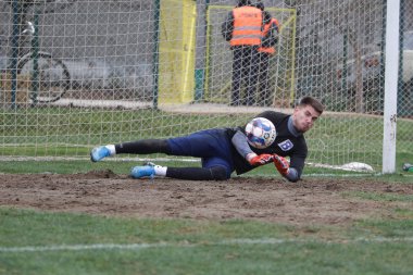 Odessa, Ukrayna - 2019 yılı: Yerel bir futbol takımının kalecisi, kötü bir futbol sahasında bölgesel bir derbi şampiyonasında oynarken kurtarıyor. Futbol golü, gol kalesi