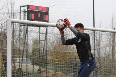 Odessa, Ukrayna - 2019 yılı: Yerel bir futbol takımının kalecisi, kötü bir futbol sahasında bölgesel bir derbi şampiyonasında oynarken kurtarıyor. Futbol golü, gol kalesi