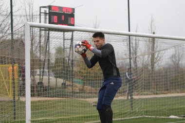 Odessa, Ukrayna - 2019 yılı: Yerel bir futbol takımının kalecisi, kötü bir futbol sahasında bölgesel bir derbi şampiyonasında oynarken kurtarıyor. Futbol golü, gol kalesi