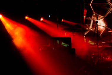 Tiyatro sahnesi rock konseri. Projektör demetleri, ışık, konserin soyut arkaplanı. Işık sırasında sahne ışıkları ve gösterinin eşlik ettiği müzik. Karanlık arka plan, duman, spot ışıkları. Parlak ateş