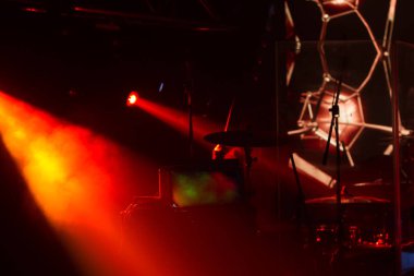 Tiyatro sahnesi rock konseri. Projektör demetleri, ışık, konserin soyut arkaplanı. Işık sırasında sahne ışıkları ve gösterinin eşlik ettiği müzik. Karanlık arka plan, duman, spot ışıkları. Parlak ateş