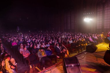 Odessa, Ukrayna-2019: konserde büyük bir izleyici kitlesi. Tiyatrodaki izleyiciler çakmak ve cep telefonlarını kaldırmış insan siluetlerine doğrultuyor. Koyu arkaplan parlak ışıklar