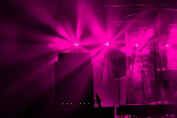 Theatrical stage rock concert. Beams of searchlights, light, abstract background of concert. Stage lights during light and music accompaniment of show. Dark background, smoke, spotlights. Bright fire