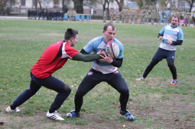 Odessa, Ukrayna 24 Kasım 2019: Rugby Derbisi turnuvasında yerel ragbi kulüpleri yeşil donanımsız sahada şiddetli bir kavgaya tutuştu. Rugby atletlerinin stadyum açıklamalarında şiddetli çatışmalar yaşandı. Savaş
