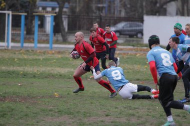 Odessa, Ukrayna 24 Kasım 2019: Rugby Derbisi turnuvasında yerel ragbi kulüpleri yeşil donanımsız sahada şiddetli bir kavgaya tutuştu. Rugby atletlerinin stadyum açıklamalarında şiddetli çatışmalar yaşandı. Savaş