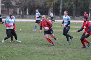 Odessa, Ukrayna 24 Kasım 2019: Rugby Derbisi turnuvasında yerel ragbi kulüpleri yeşil donanımsız sahada şiddetli bir kavgaya tutuştu. Rugby atletlerinin stadyum açıklamalarında şiddetli çatışmalar yaşandı. Savaş