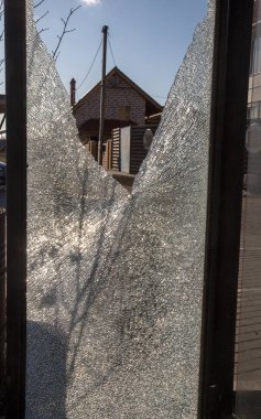 Otobanda kırık cam otobüs durağı. Vandallar camı kırdı. Küçük parçalar ve sertleştirilmiş cam çatlakları. Holiganlık, vandalizm ve suç geçmişi
