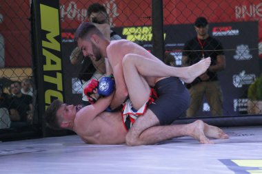 Odessa, Ukrayna-30 Haziran 2019: Mma boksörlerinin dövüşçüleri sekizgen kafes ringinde kuralsız dövüşüyorlar. Mma dövüşçüleri şampiyonada ringde