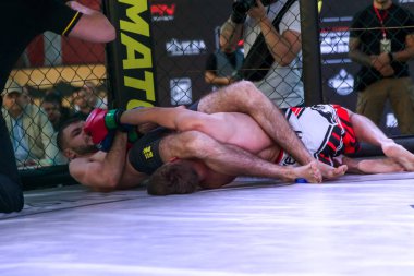 Odessa, Ukrayna-30 Haziran 2019: Mma boksörlerinin dövüşçüleri sekizgen kafes ringinde kuralsız dövüşüyorlar. Mma dövüşçüleri şampiyonada ringde