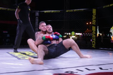 Odessa, Ukrayna-30 Haziran 2019: Mma boksörlerinin dövüşçüleri sekizgen kafes ringinde kuralsız dövüşüyorlar. Mma dövüşçüleri şampiyonada ringde