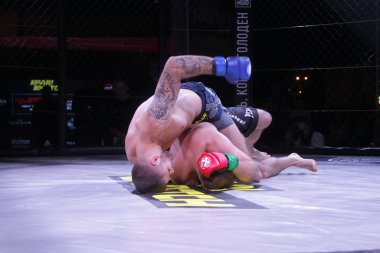 Odessa, Ukrayna-30 Haziran 2019: Mma boksörlerinin dövüşçüleri sekizgen kafes ringinde kuralsız dövüşüyorlar. Mma dövüşçüleri şampiyonada ringde