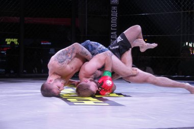 Odessa, Ukrayna-30 Haziran 2019: Mma boksörlerinin dövüşçüleri sekizgen kafes ringinde kuralsız dövüşüyorlar. Mma dövüşçüleri şampiyonada ringde